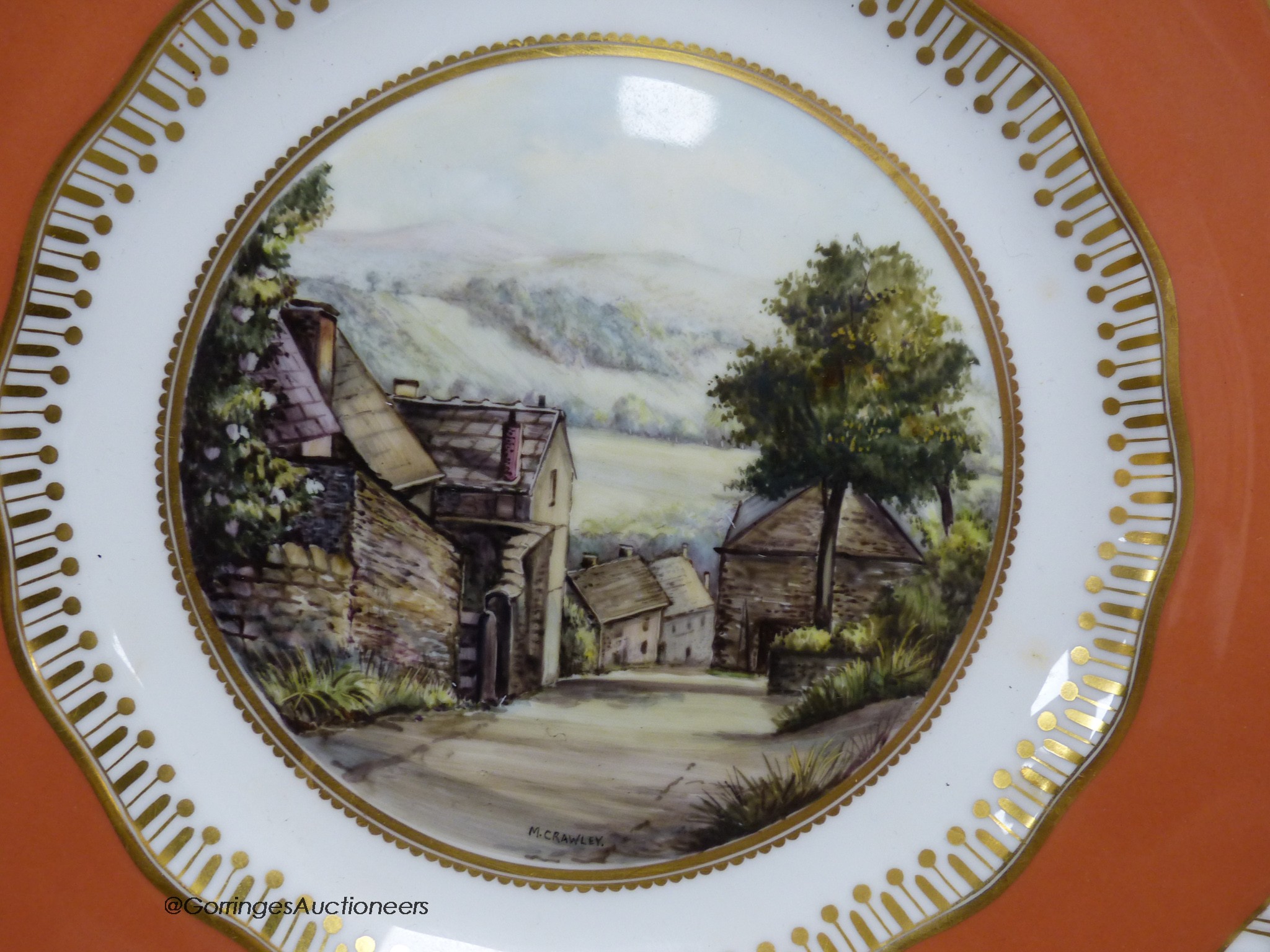 A Royal Crown Derby plate painted with a view of Stoney Middleton, Derbyshire under a burnt orange border by M. Crawley, signed, 23cm diameter